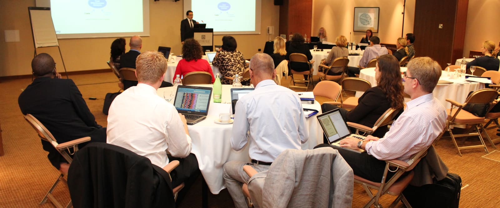 Delegates working at round tables during a conference organised by Adria Congress