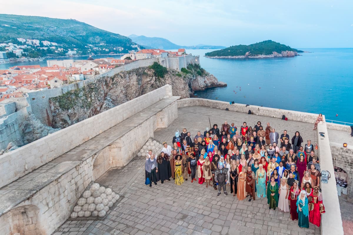An event group photographed on the Dubrovnik city walls above the sea